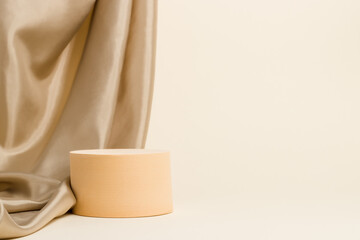 Round cylinder shape display with textile at the background, podium for product presentation