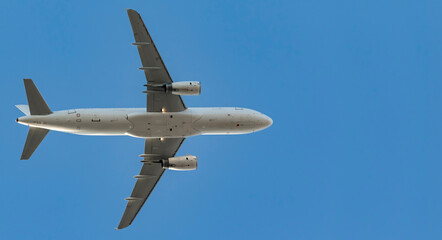 Fototapeta na wymiar Airplane in flight against blue sky
