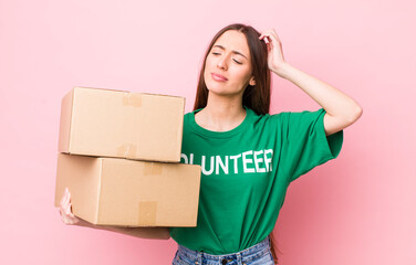 hispanic pretty woman feeling puzzled and confused, scratching head. volunteer concept