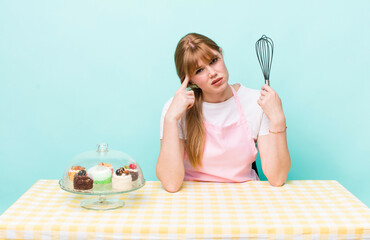red head pretty woman feeling confused and puzzled, showing you are insane. home made cakes concept