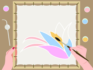 Vector graphics - hands with a brush draw a flower on a fabric stretched on a square stretcher close-up. Concept hand craft batik and hobby