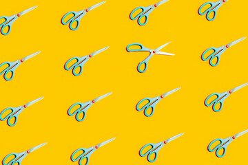 Repetitive pattern with scissors on yellow background.