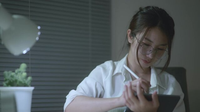 Young Beautiful business woman typing on iPad working at home. Working in room. Morning window light. Soft mood and soft focus.