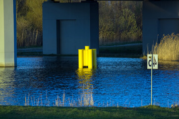 Duża żółta pływająca boja na rzece pod mostem