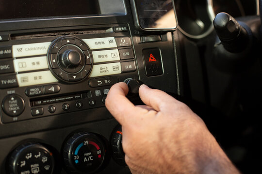 Car dashboard. Radio closeup. man sets up radio
