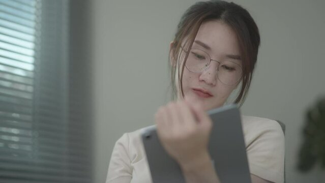 Young Beautiful business woman typing on iPad working at home. Working in room. Morning window light. Soft mood and soft focus.