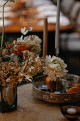Wedding decor at the restaurant. Beautiful table setting with autumn flowers, orange and burning candles. Autumn wedding concept