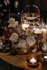 Wedding decor at the restaurant. Beautiful table setting with autumn flowers, orange and burning candles.