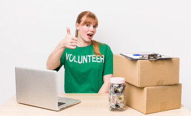 red head pretty woman feeling proud,smiling positively with thumbs up. Donation volunteer concept