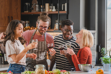 Young diverse people having a home party, preparing food, drinking, having fun