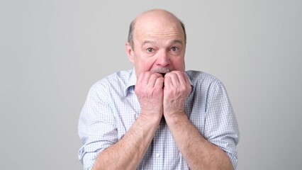 Senior man biting his nails fingers freaking out.