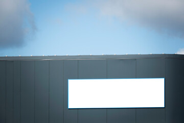 Mock up template. Big horizontal white blank signboard, advertising billboard on modern building...