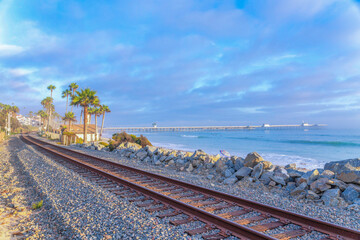 Fototapeta na wymiar Rusty train tracks with a view of the ocean and pier at San Clemente, California