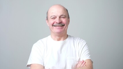 Handsome senior man in white t-shirt laughing