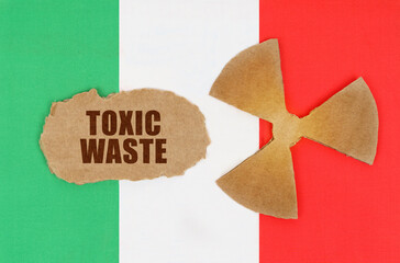 On the flag of Italy, the symbol of radioactivity and torn cardboard with the inscription - Toxic...