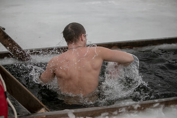 Baptism, bathing in the winter ice hole, beautiful winter landscape with an ice cross on a frozen river