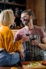 Beautiful young hipster love couple toasting with wine at home