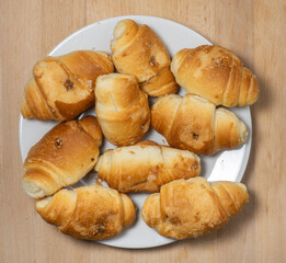 Many small croissants on a white background. Croissants with boiled condensed milk. Confectionery in the kitchen.