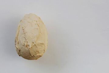 Decorative egg covered with plaster on the background.