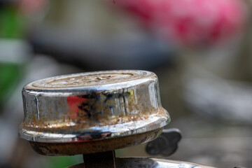 old rusty metal bell on pink saddle background, bokeh