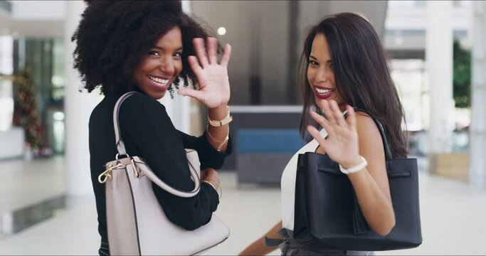 Were well on our way to our next big success. 4k video footage of two young businesswomen showing thumbs up and waving while walking in an office.