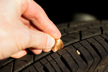 Checking tread depth on a tire by using a penny