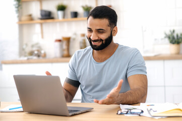 Online communication, briefing. Positive Indian or Arabian successful man, company coworker, works...