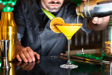 Bartender serving a cocktail in a night club bar