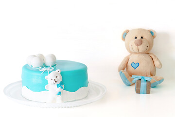 Baby blue delicious cake decorated with gift box and teddy bear for child's first birthday celebration. set with blue colors decorations for baby shower party for boy