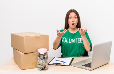 hispanic pretty woman feeling extremely shocked and surprised. donations volunteer