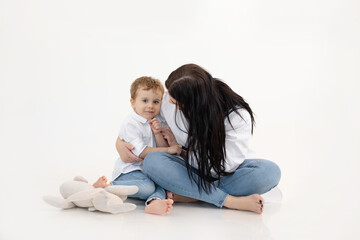 Studio shot of two people, woman and boy having fun and cuddling, talking to each other. Family weekend activity goals