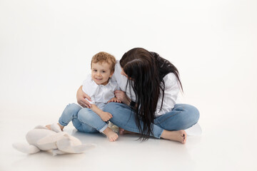 Studio shot of two people, woman and boy having fun and cuddling, talking to each other. Smiling child boy near mother