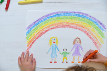 Crop kid drawing LGBT family on table