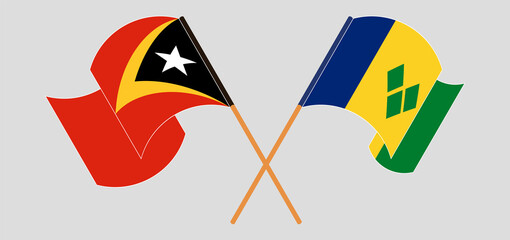 Crossed and waving flags of East Timor and Saint Vincent and the Grenadines