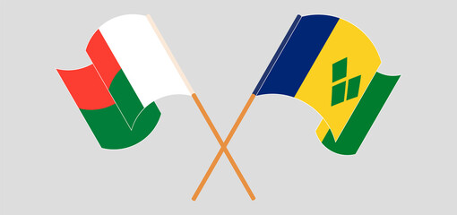 Crossed and waving flags of Madagascar and Saint Vincent and the Grenadines