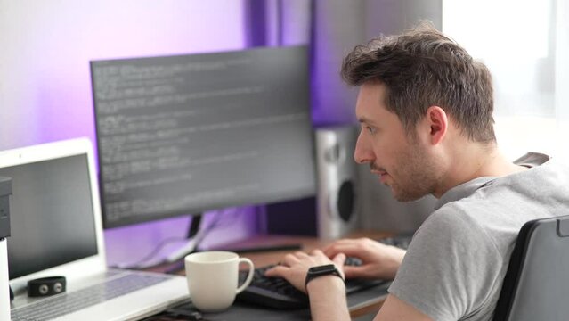 Male programmer working at home. Programmer coding from home office.