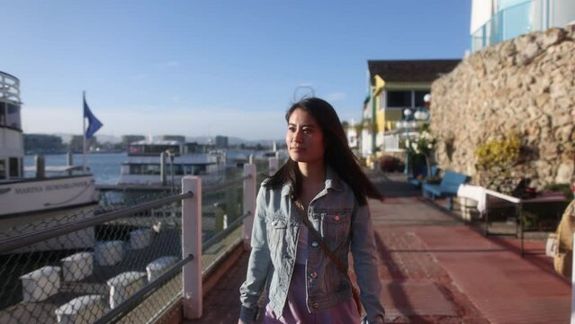 A young Asian woman walking through Marina del Rey, a famous tourist destination in Los Angeles