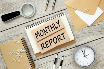 Monthly Report, Flat lay style. text on wooden blocks.