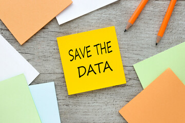 save the date. text on orange sticky note on wooden background