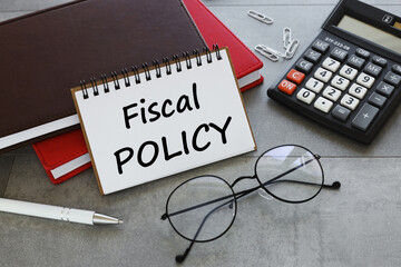 fiscal policy brown and red notebook. text on open deck.