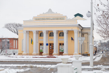 Palace of culture in name of Taras Shevchenko, famous Ukrainian poet and writer at winter day. Street covered with snow - obrazy, fototapety, plakaty