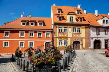 Cheb, Western Bohemia, Czech Republic, 14 August 2021: picturesque street with medieval colorful gothic houses, Fountain of St. Nicholas at Ruzovy kopecek at sunny summer day, baroque buildings