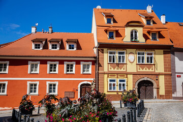 Cheb, Western Bohemia, Czech Republic, 14 August 2021: picturesque street with medieval colorful gothic houses, Fountain of St. Nicholas at Ruzovy kopecek at sunny summer day, baroque buildings