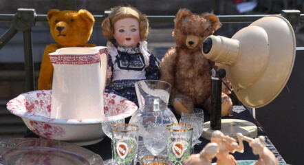 Stand mit Teddys, Puppen und Geschirr auf einem Flohmarkt