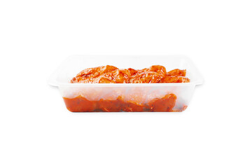 Marinated chicken wings in red sauce on isolated white background.Copy space.Semifinished. Fast cooking.Raw marinated chicken meat.Side view.