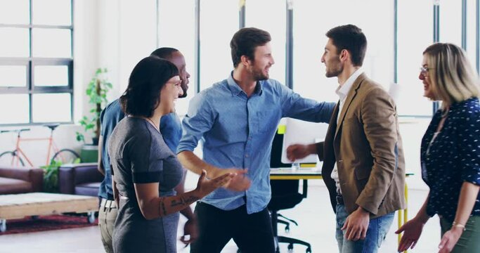 Im so proud of all of you.Group of coworkers cheering and celebrating success in a modern office. Cheerful diverse group of businesspeople high fiving and celebrating in the office.