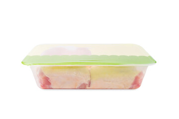 Chicken thigh meat in a tray for a supermarket.Transparent tray with meat inside on an isolated background.Side view.Raw chicken thigh with skin for cooking.