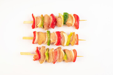 Frozen pieces of chicken skewers fillet with vegetables on white background.Chicken fresh skewers...