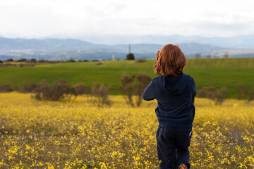Chico jugando en el campo de flores amarillas