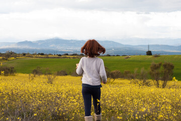 Chica jugando en el campo de flores amarillas